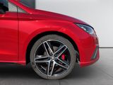 a red car parked in front of a white wall