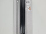 un gros plan sur un paquet de stylos noirs posé sur une surface blanche