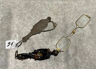 deux paires de lunettes et une paire de ciseaux posées sur une table