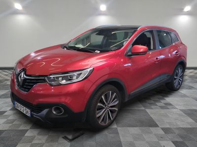 une voiture rouge garée sur le sol en damier d'un garage