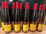 six bouteilles de vin sont alignées sur une table