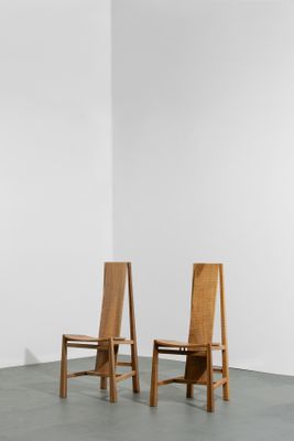 deux chaises en bois dans une pièce blanche aux murs blancs