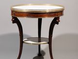une table ronde avec un plateau en marbre et des pieds en bois