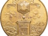 a close up of a gold coin with a building on it