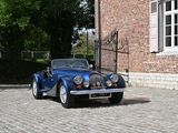 a blue car that is parked in front of a brick building
