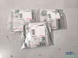 three bags of screws and nuts are sitting on a table
