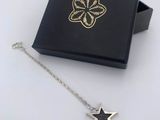 a black box with a silver star charm and a black box with a gold star charm
