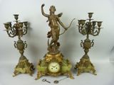 trois horloges différentes et une statue posées sur la table