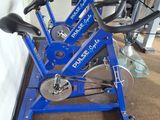a blue exercise bike with a towel on the floor