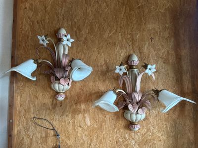 two wall sconces on the wall with flowers on them