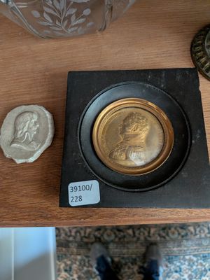 une pièce d'or posée sur une table, à côté d'un vase en verre