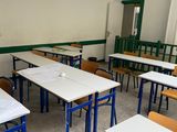 tables and chairs in an empty classroom with no one sitting at the desk