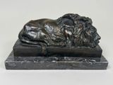 statue en bronze représentant un lion posé sur un socle en marbre