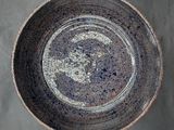 an overhead view of a bowl on a table with a gray background
