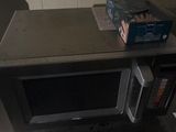a microwave that is sitting on a shelf in the kitchen