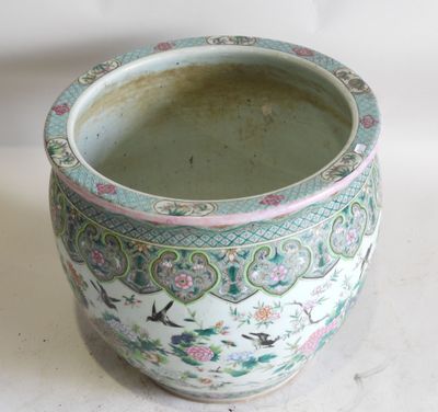 un vase vert et rose posé sur une surface blanche