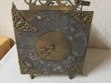 une horloge posée sur une table à côté d'une feuille de papier