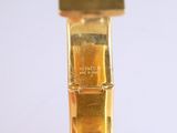 a close up of a gold wrist watch on a white surface