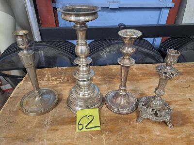 trois bougeoirs en argent posés sur une table, accompagnés d'une étiquette de prix