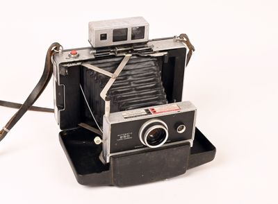 an old polar camera sitting on top of a black stand