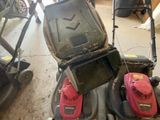 deux tondeuses à gazon et une tondeuse à gazon dans un garage