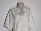 an image of a mannequin wearing a white top with crochets on it