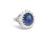 un gros plan sur une bague sertie d'un saphir étoilé bleu et de diamants