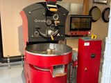 un moulin à café rouge posé dans une pièce, à côté d'une poubelle rouge