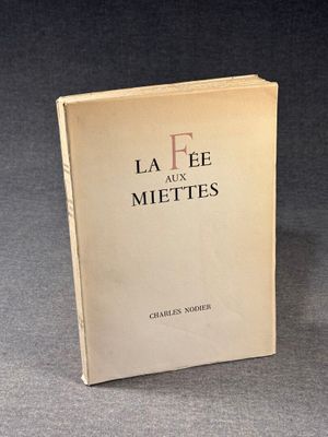 an old book sitting on top of a table on a gray surface