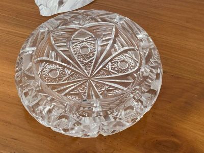 un saladier en verre posé sur une table en bois, à côté d'une serviette en papier