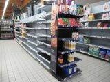 many empty shelves in a grocery store filled with food