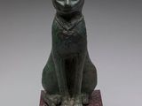 an egyptian bronze statue of a cat sitting on top of a base