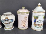 four different types of ceramic containers are lined up on a black surface