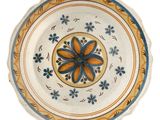 a plate with a flower design on it on a white surface