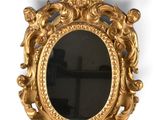 une image d'un miroir encadré d'or sur un mur blanc