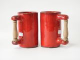 pair of red mugs with wooden handles on a white surface