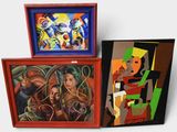 three paintings that are on display on a white surface