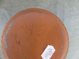 a brown vase with a tag on it sitting on a table