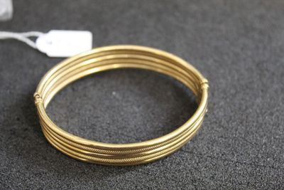 un gros plan sur une paire de bracelets en fil métallique de couleur dorée posés sur une table