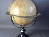 an old model of a terrestrial globe on a metal stand