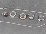 tout un tas de bagues et de colliers différents posés sur la table