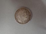 a silver coin on a table with a white background