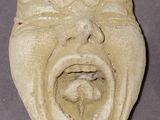 a clay sculpture of a laughing face on a table