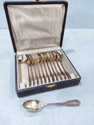 silverware in a case with spoons and spoon rest on a table