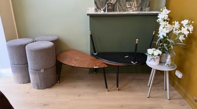 une petite table avec deux tabourets et un vase de fleurs