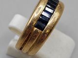 a close up of a gold ring with a blue sapphire stone