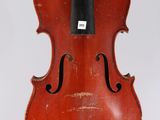 an old violin hanging from a string on a white wall