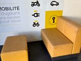 a small chair and a small ottoman in front of a sign