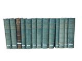 several old books are lined up in a row on a white surface