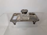 a silver tray with a glass candle holder on top of it